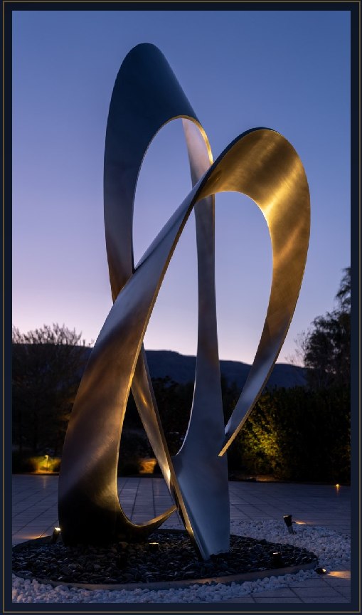 Illuminated metal sculpture at dusk, an example of Twilight Designs' architectural lighting work