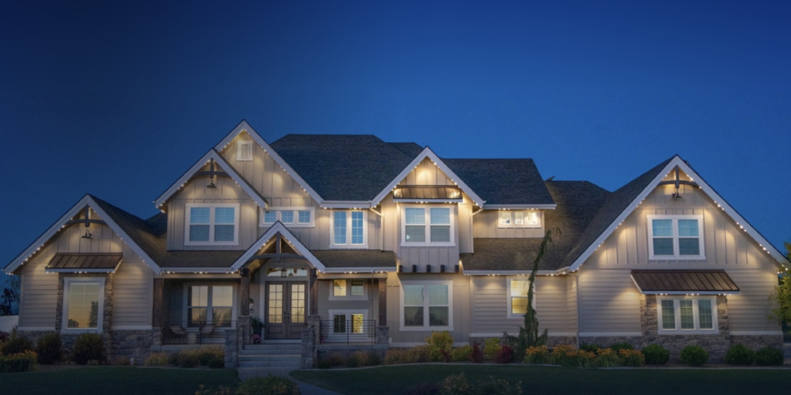 Large Las Vegas home at dusk with warm-white permanent lighting along every roofline